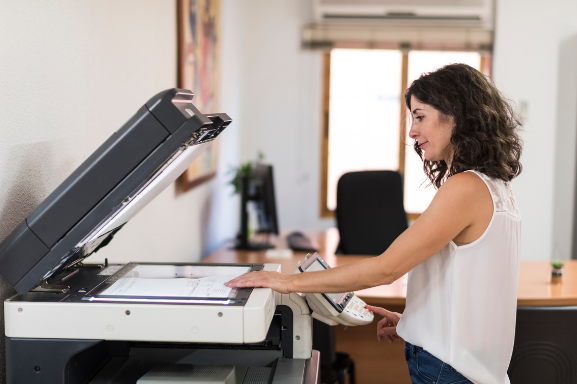 A woman using office copiers