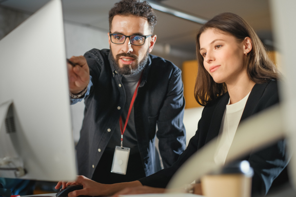 Two businesspeople staring at a computer screen to signify Managed IT Services.