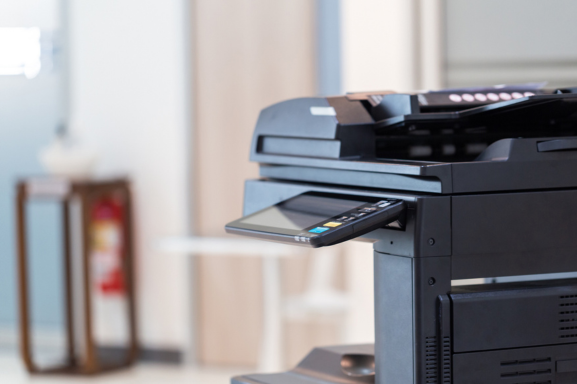 Close up of a sleek, black multifunction printer in an office setting.