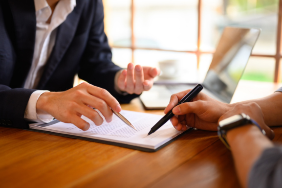 Close up of two business men reviewing a copier lease at a table.
